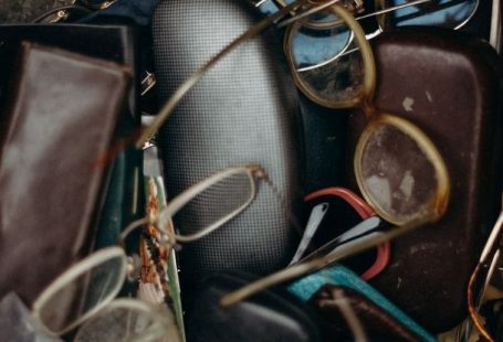 Swap Meet - Black and Brown Leather Bifold Wallet Beside Black Framed Eyeglasses