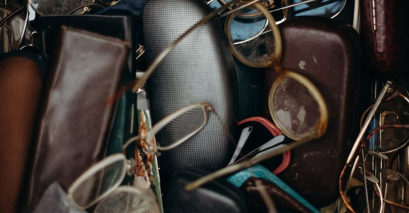 Swap Meet - Black and Brown Leather Bifold Wallet Beside Black Framed Eyeglasses