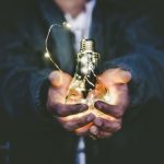 Energy Saving - man holding incandescent bulb