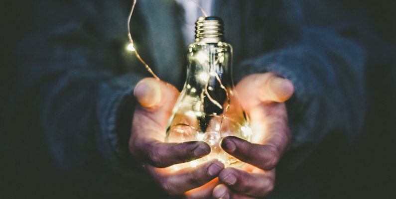 Energy Saving - man holding incandescent bulb