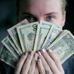 Gift-giving Budget - person holding fan of U.S. dollars banknote