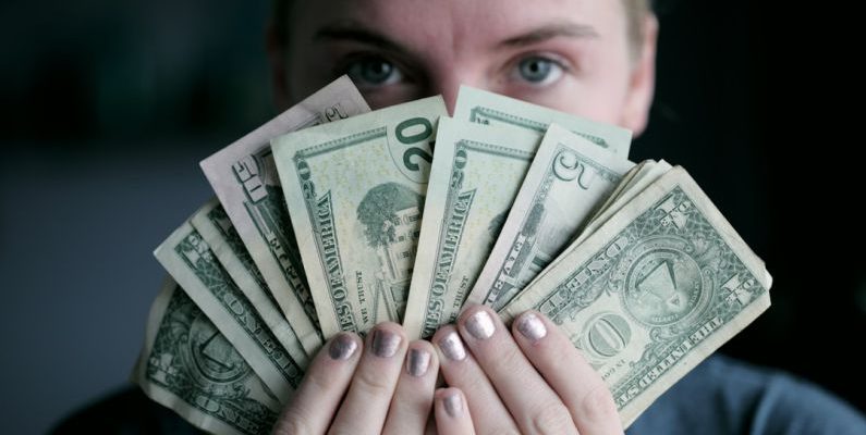 Gift-giving Budget - person holding fan of U.S. dollars banknote