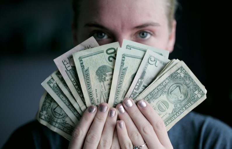 Gift-giving Budget - person holding fan of U.S. dollars banknote