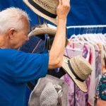 Clothing Shopping - A man and woman are looking at hats at a market