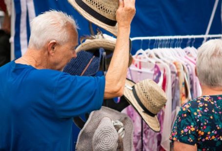 Clothing Shopping - A man and woman are looking at hats at a market