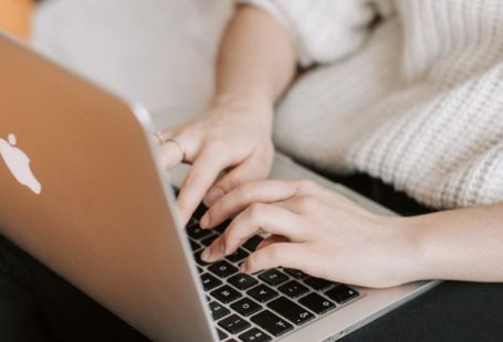 Discount App - Crop woman typing on laptop on bed