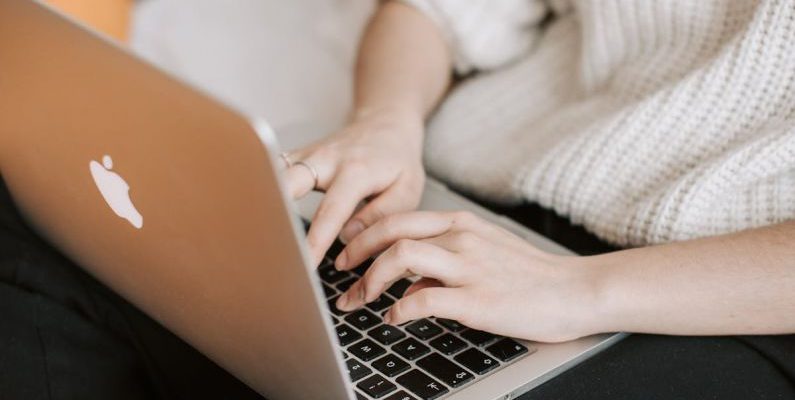 Discount App - Crop woman typing on laptop on bed