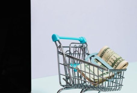 Electronics Sale - Shopping Cart with Money on Top of a Laptop