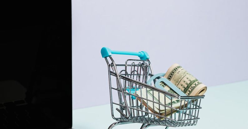 Electronics Sale - Shopping Cart with Money on Top of a Laptop