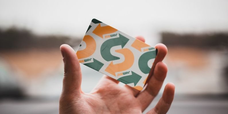 Coupon Stacking - person holding green and white card