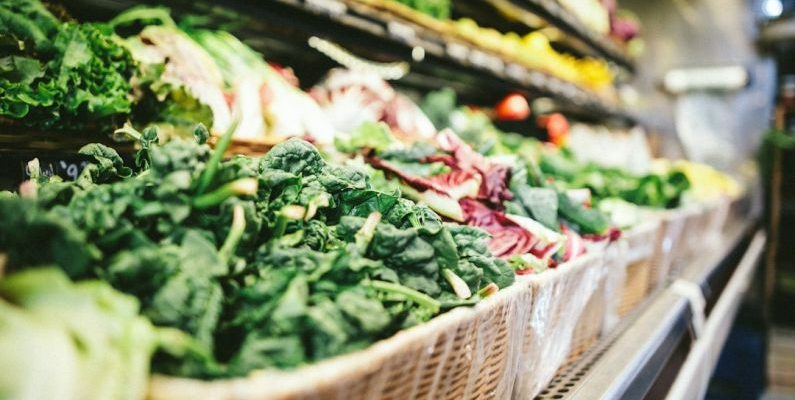 Grocery Coupon - row of vegetables placed on multilayered display fridge