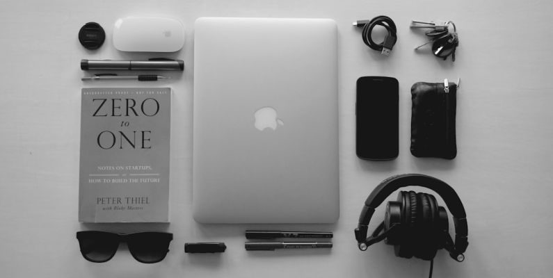 Bulk Items - silver MacBook near black corded headphones and assorted items