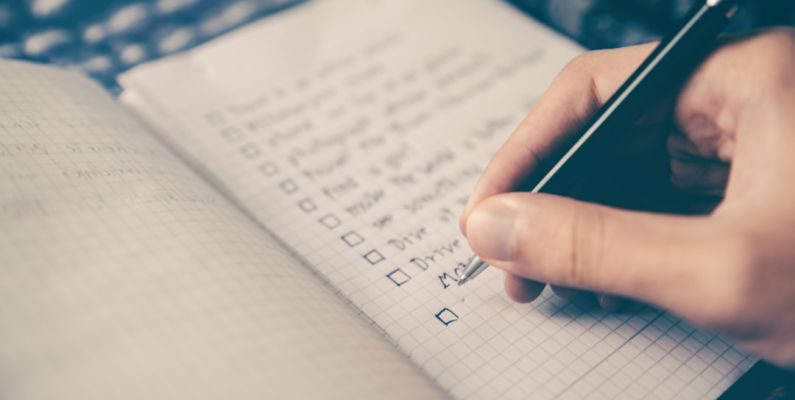 Grocery List - person writing bucket list on book