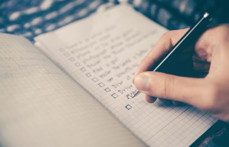 Grocery List - person writing bucket list on book