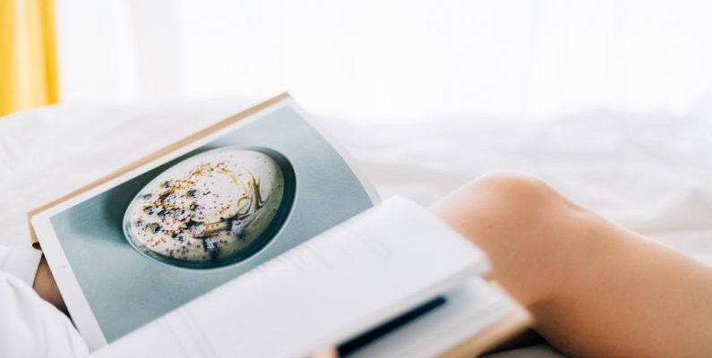 Weeknight Recipes - person holding open magazine while laying on bed